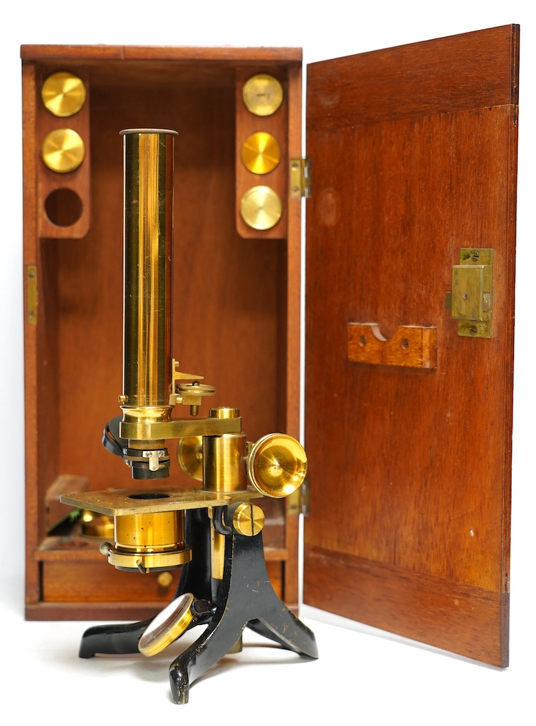 An unmarked late 19th century monocular brass microscope, in a fitted mahogany case with alternative lenses, a drawer for slides and other accessories, case 39cm high. Condition - fair to good